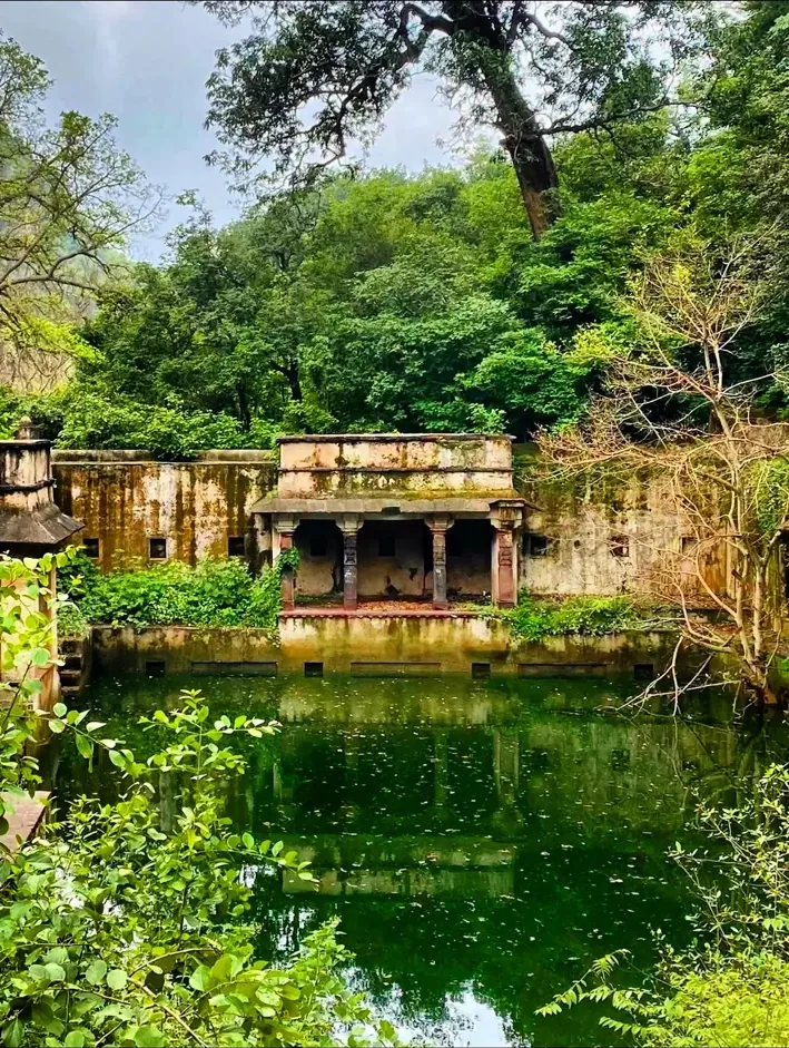 Historic pavilion beside a green water body